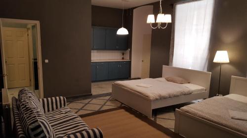 布达佩斯普瑞梅尔公寓旅馆的一间带床的小卧室和一间厨房