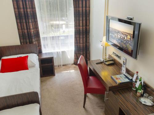 布拉格EA水晶宫酒店的酒店客房配有一张床和一张书桌及一台电视