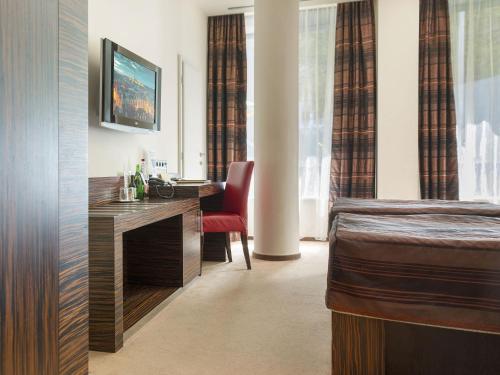 布拉格EA水晶宫酒店的配有一张床和一张书桌的酒店客房