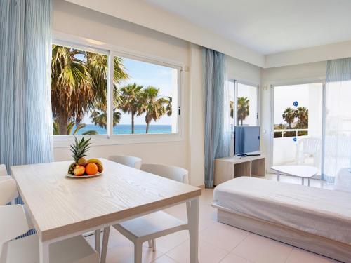 卡拉博纳Grupotel Mallorca Mar的一间卧室配有一张床和一张带水果的桌子