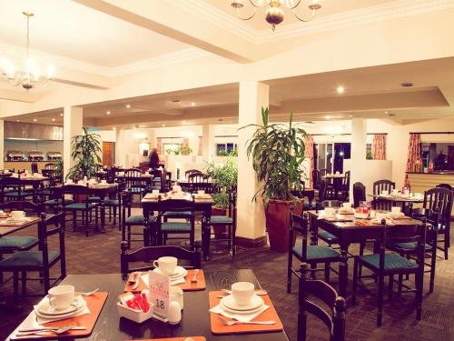 派恩敦Premier Splendid Inn Pinetown的餐厅内带桌椅的用餐室