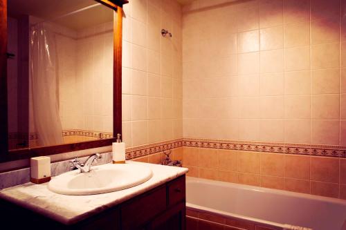 邦蒙特特雷斯诺维斯Apartment Bonmont的浴室配有盥洗盆、镜子和浴缸