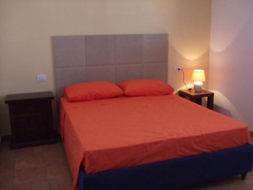切萨雷奥港Residence La Corte的一间卧室配有红色的床和两个红色枕头