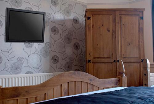 科尔斯希尔乔治与龙酒店的卧室配有一张床,墙上配有电视。