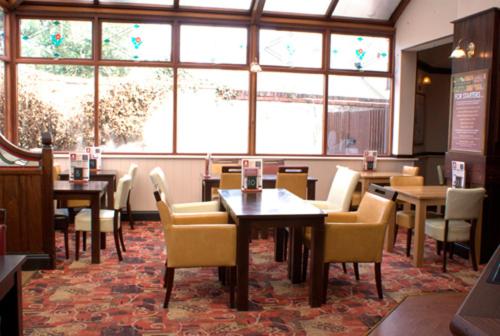 科尔斯希尔乔治与龙酒店的用餐室设有桌椅和窗户。