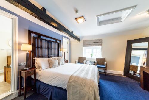 韦尔文白鹿酒店的一间卧室配有一张大床和镜子
