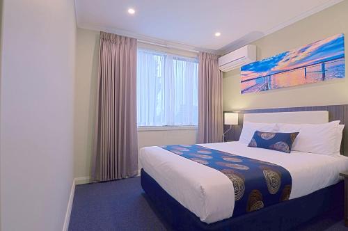 墨尔本帕克斯奎尔汽车旅馆和服务式公寓的酒店客房设有床和窗户。