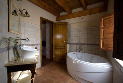 比利亚尔潘多波萨达罗斯克恩德斯塔布勒斯酒店和Spa的浴室配有大型白色浴缸和水槽