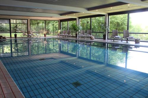 施内沃丁根兰德哈昊鹏酒店的一个带椅子和窗户的大型游泳池