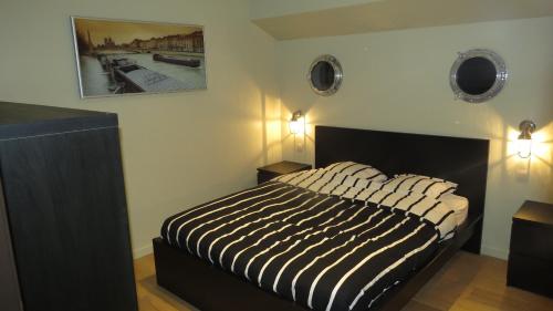 伊普尔Bed in Boat的一间卧室配有一张带黑白条纹棉被的床