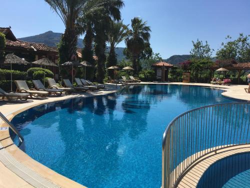 达利安Asur Hotel & Aparts & Villas的一个带椅子和棕榈树的大型游泳池