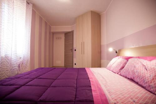 巴尼奥雷焦Casa Vacanze Evelina的一间卧室配有紫色床和紫色毯子