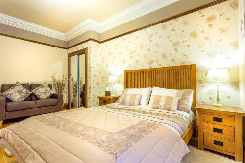 斯特兰拉尔Thornbank House的一间卧室配有一张大床和一张沙发