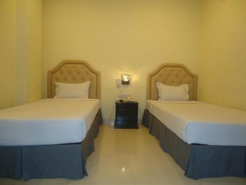 吉大港行政旅馆的两张位于酒店客房的床,配有两张sidx sidx单人床