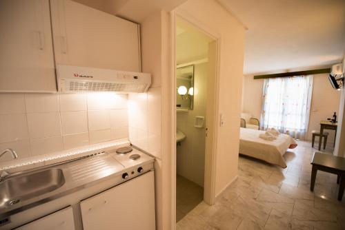 奈德里Hotel Niras的带水槽的厨房和1间带床的房间