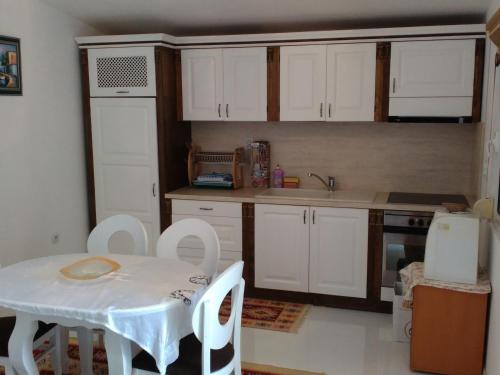 Paralía AvdhíronVilla Avdira的厨房配有白色橱柜和桌椅