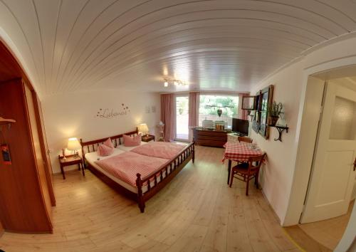 巴登-巴登Hotel Merkurwald - Restaurant Wolpertinger的卧室配有一张床和一张桌子
