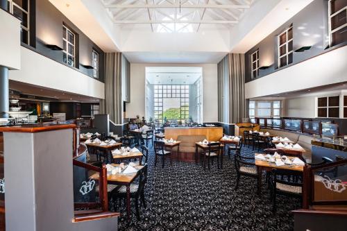 EppingCity Lodge Hotel GrandWest的餐厅内带桌椅的用餐室