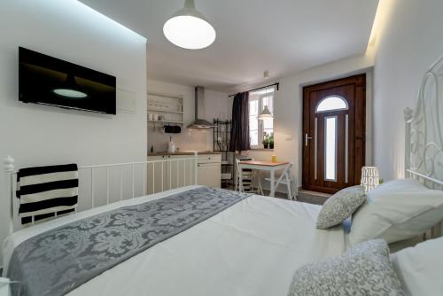 苏佩塔尔里瓦之家公寓的一间白色卧室,配有一张大床和一个厨房