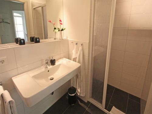巴贝Haus Meeresblick - Ferienwohnung Fischerhüs (Ref. 138713)的白色的浴室设有水槽和淋浴。