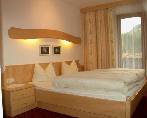盖洛斯Gästehaus Elfriede旅馆的一间卧室设有一张大床和窗户