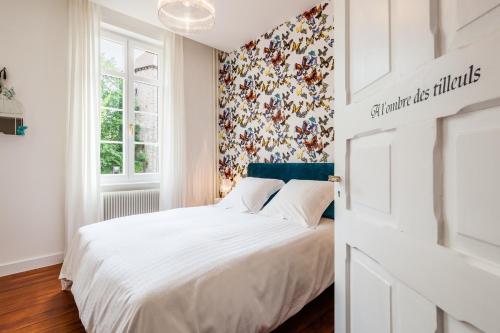 维桑堡Chambre d'hôtes Du côté des remparts的卧室配有白色的床和花卉壁纸