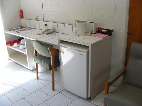 拉罗汤加森特尔汽车旅馆的厨房配有带冰箱和桌子的柜台