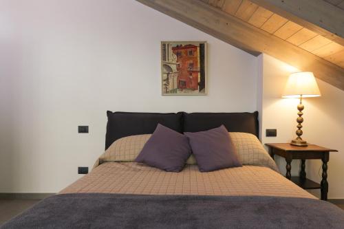 莱萨Italian Lakes Apartment 14009的一间卧室配有一张带两个紫色枕头的床