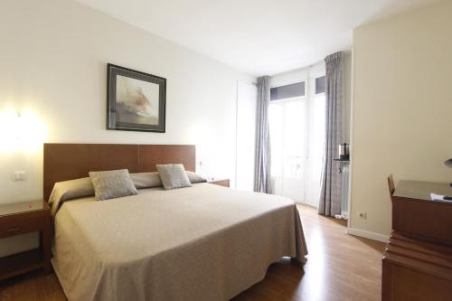 马德里格兰大道街角酒店的一间卧室设有一张大床和一个窗户。