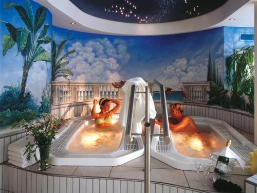 施科佩尔瑙Sporthotel Krone的两名女性使用酒店客房内的热水浴池