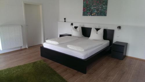 厄斯特里希-温克尔Zum Rebhang Bed & Breakfast的一间卧室配有带白色床单和枕头的床。