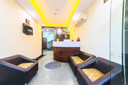加尔各答Treebo Trend Globe International的一间设有两张皮椅和酒吧的房间