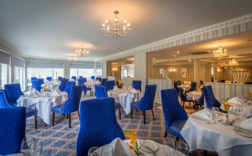 基尔肯尼基尔肯尼河苑酒店的宴会厅配有桌椅和吊灯。