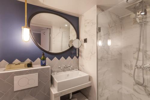 巴黎Handsome Hotel的一间带水槽、淋浴和镜子的浴室