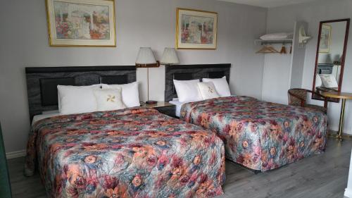 尼亚加拉瀑布7 Nights Stay的酒店客房设有两张床和一张桌子。