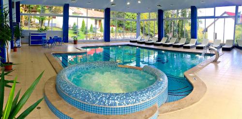 萨克德佐尔镇Alva Hotel & Spa的一座大楼内一座带浴缸的大型游泳池