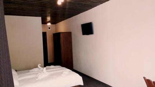 FotinovoFamily hotel Valchanovata Kashta的一间卧室设有两张床,墙上配有电视。