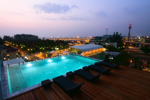 奈扬海滩The Sixteenth Naiyang Beach Hotel SHA Plus的一座游泳池,在晚上在一座建筑的顶部