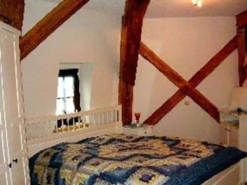 BrunshauptenAppartements An der Muehle的卧室配有一张床铺,位于带木梁的房间