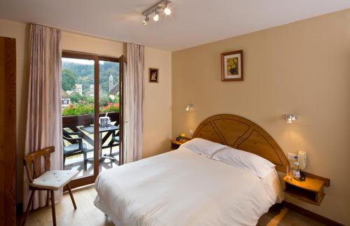吉奥弗特尔奥维墨林酒店的一间卧室配有一张床,阳台配有桌子