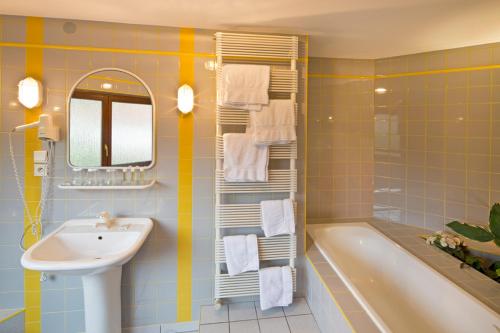 吉奥弗特尔奥维墨林酒店的一间带水槽、浴缸和镜子的浴室