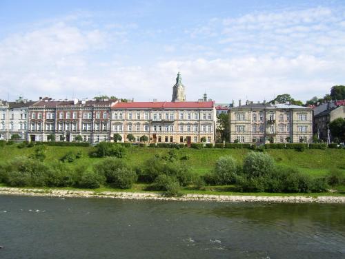 普热梅希尔Pokoje Gościnne的河边小山上的大建筑