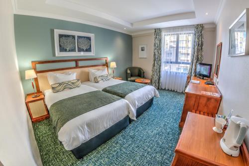 德班City Lodge Hotel Umhlanga Ridge的酒店客房设有一张大床和一张书桌。