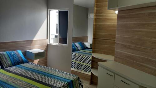 马塞约Apart Cote D'Azur Maceió的小房间设有两张床和镜子