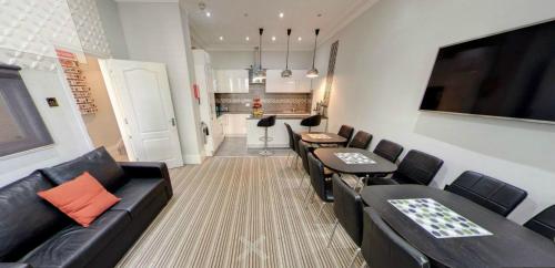 伦敦GRN康福特尔酒店的一间带黑色皮革家具的客厅和厨房