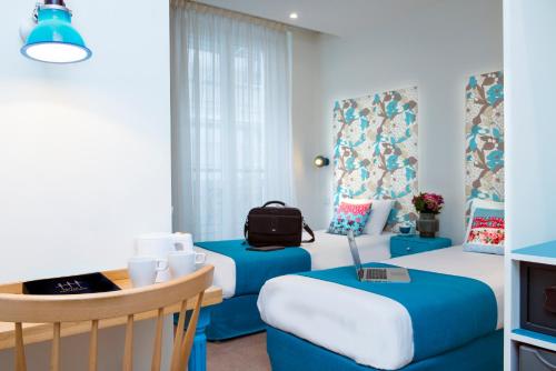 巴黎波西米亚别墅酒店的一间设有两张床和一张桌子及椅子的房间