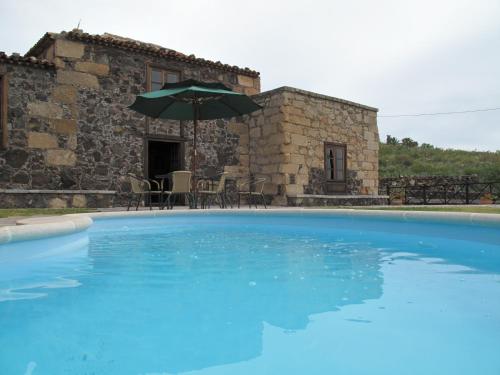 圣米格尔德阿沃纳维拉德拉霍亚乡村旅馆的大楼前的大型蓝色游泳池