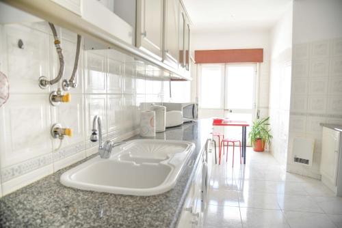 拉戈斯Lagos Bay View Flat的一间白色的厨房,在房间内配有水槽