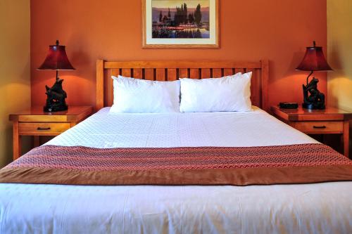 布赖恩峰钻石度假村雪松度假酒店的一间卧室配有一张大床,桌子上放着两盏灯