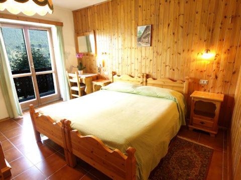 尚波吕克阿尔卑斯弗罗瑞酒店的一间卧室配有一张床、一张桌子和一个窗户。
